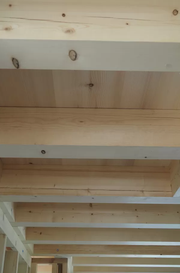 Holzbalkendecke aus hellen Fichtenbrettern, sauber verarbeitet und Teil einer Holzbaukonstruktion.