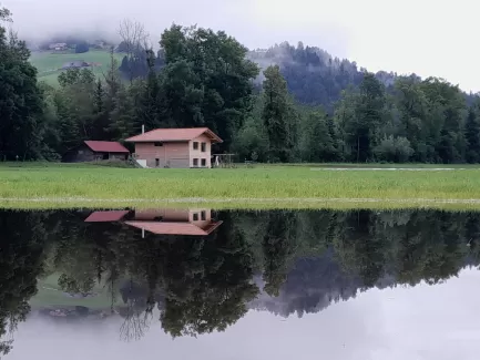 🌲🏡 **Haus am See** 🌧️🌊  Dieses wunderschöne Truberholz-Haus steht eigentlich nicht an einem See. Doch während der Regenzeit hat sich ein See gebildet, der eine malerische Szenerie schafft. 🌧️🏡 Die Spiegelung im Wasser verstärkt die idyllische Atmosphäre und zeigt, wie sehr unsere Häuser sich harmonisch in die Natur einfügen.  Erfahren Sie mehr über unsere nachhaltigen Holzhäuser