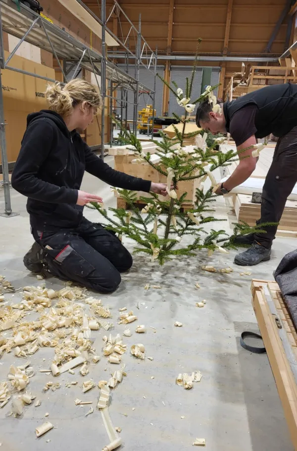 Blick in die Produktionshalle der Zimmerei Hirschi: Ein vorgefertigtes Holzmodul steht im Zentrum der Werkstatt, umgeben von Maschinen, Werkbänken und Holzbauelementen. Die industrielle Vorfertigung zeigt präzise Holzbauarbeit unter kontrollierten Bedingungen.