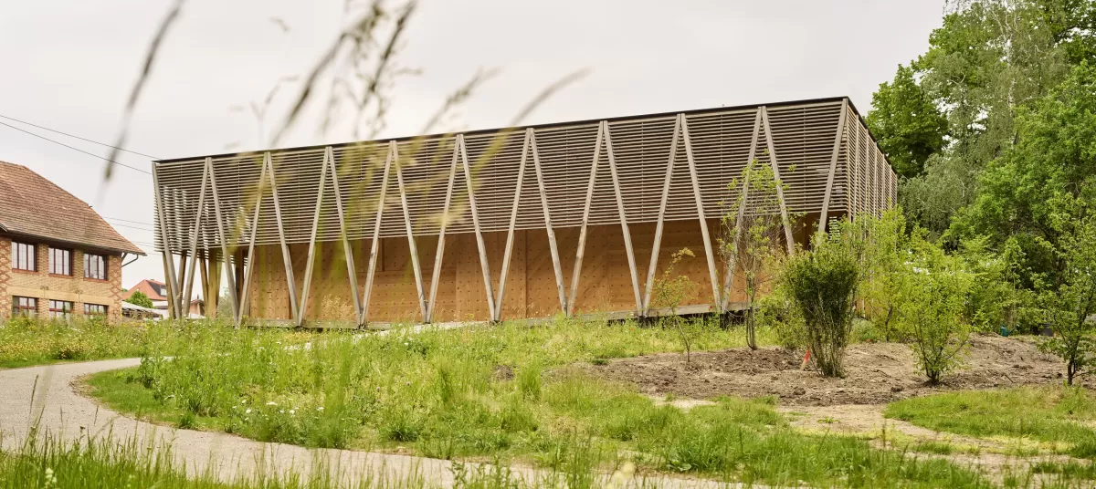  Der Kunstpavillon ist die erste Etappe des neuen Centre Albert Anker.  Am nordöstlichen Ende des idyllischen Gartens steht der Neubau zur sicheren Lagerung des Kunst- und Kulturguts von Albert Anker. Der Holzbau zitiert die traditionellen Speicher und übersetzt den Bautypus in eine zeitgenössische Architektursprache. 