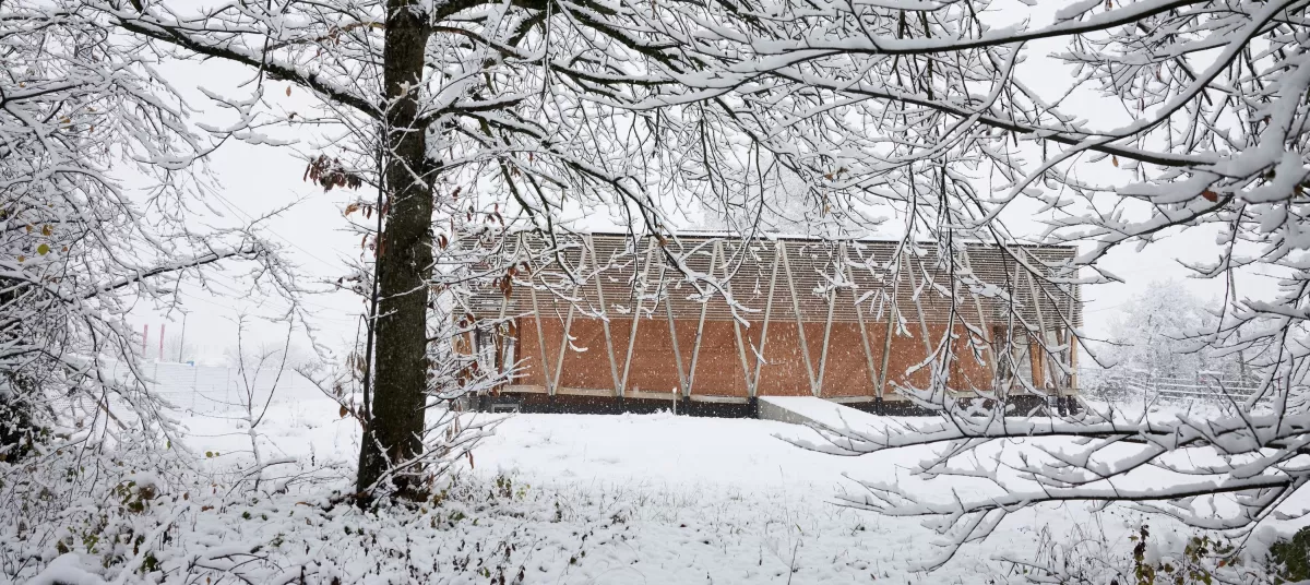  Der Kunstpavillon ist die erste Etappe des neuen Centre Albert Anker.  Am nordöstlichen Ende des idyllischen Gartens steht der Neubau zur sicheren Lagerung des Kunst- und Kulturguts von Albert Anker. Der Holzbau zitiert die traditionellen Speicher und übersetzt den Bautypus in eine zeitgenössische Architektursprache. 