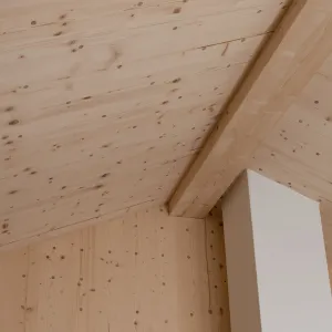 Modernes Badezimmer mit grossformatigen grauen Fliesen, Badewanne und Waschtisch mit hölzernem Unterschrank. Die helle, geneigte Holzdecke und die sichtbaren Holzelemente schaffen einen warmen Kontrast zur schlichten Badezimmereinrichtung.