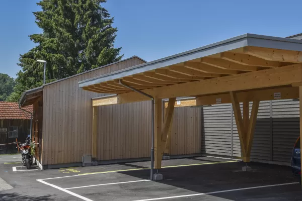 Mehrfamilienhaus in Lyss. Das Haus ist von einem Naturgarten umschlungen. Die Storen sind nach einem Farbmuster von der Bauherrin ausgewählt.