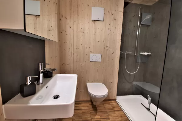 Mehrfamilienhaus in Lyss. Das Haus ist von einem Naturgarten umschlungen. Die Storen sind nach einem Farbmuster von der Bauherrin ausgewählt.